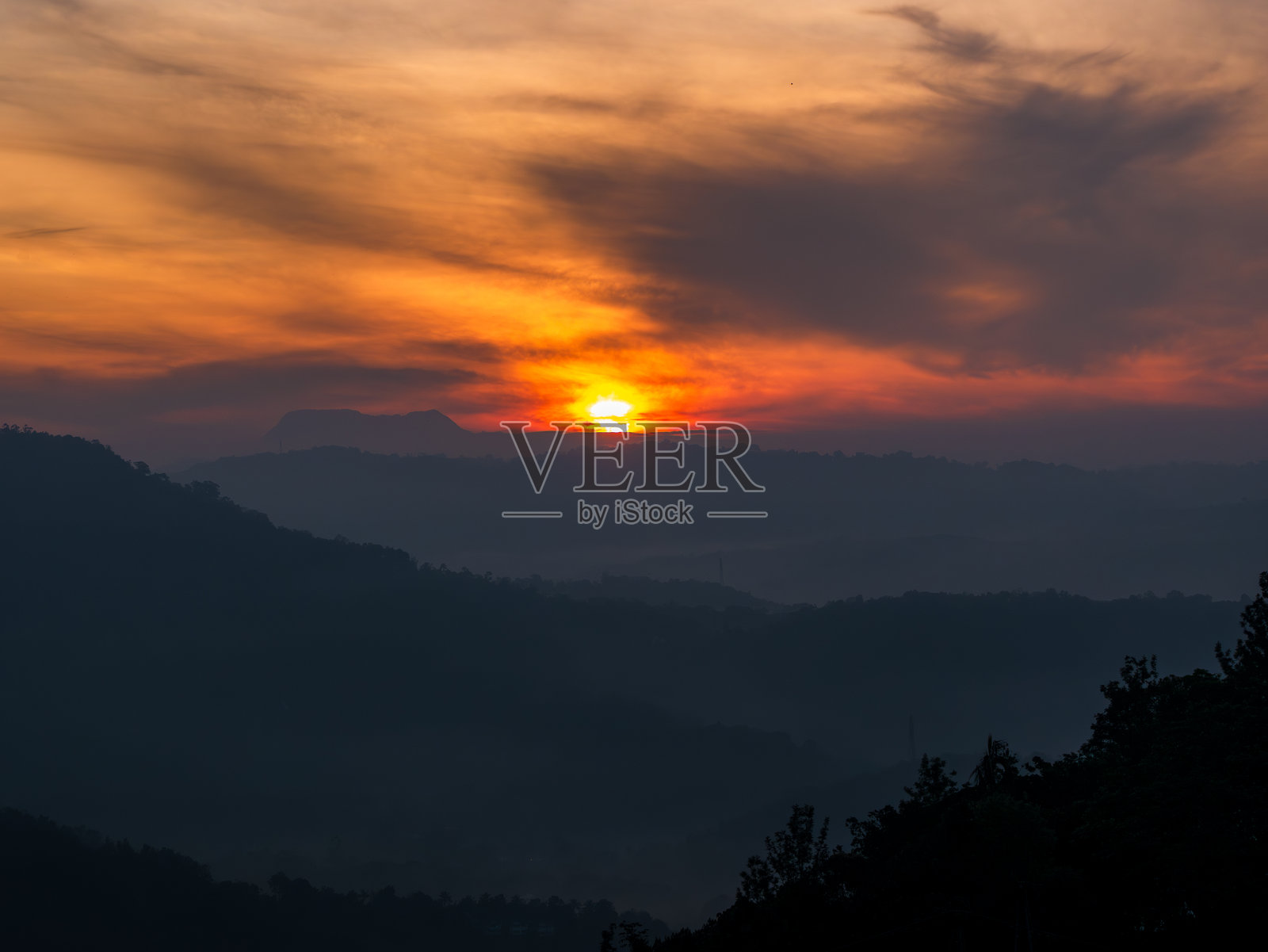 阳光透过山上的云层照片摄影图片