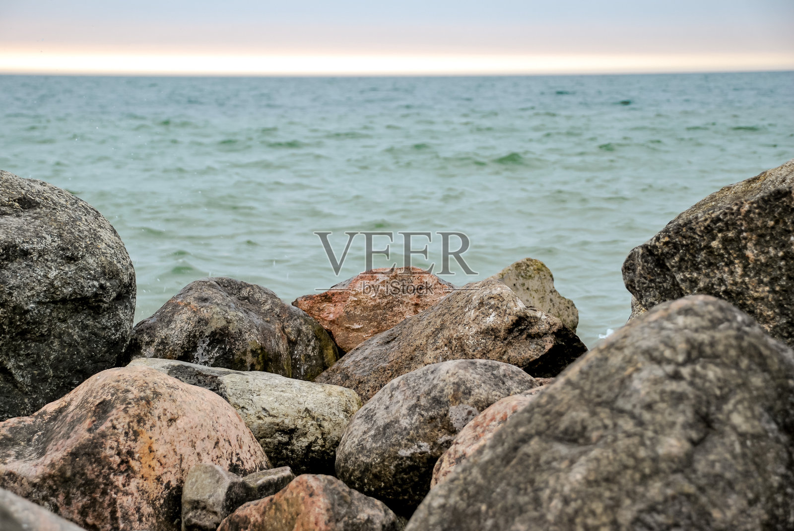 黄昏时分,岩石海岸与海浪和多云的天空照片摄影图片