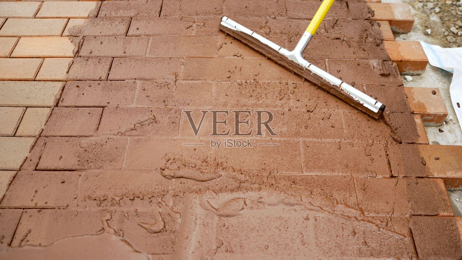 建筑工人在砖块之间涂抹填缝剂照片摄影图片