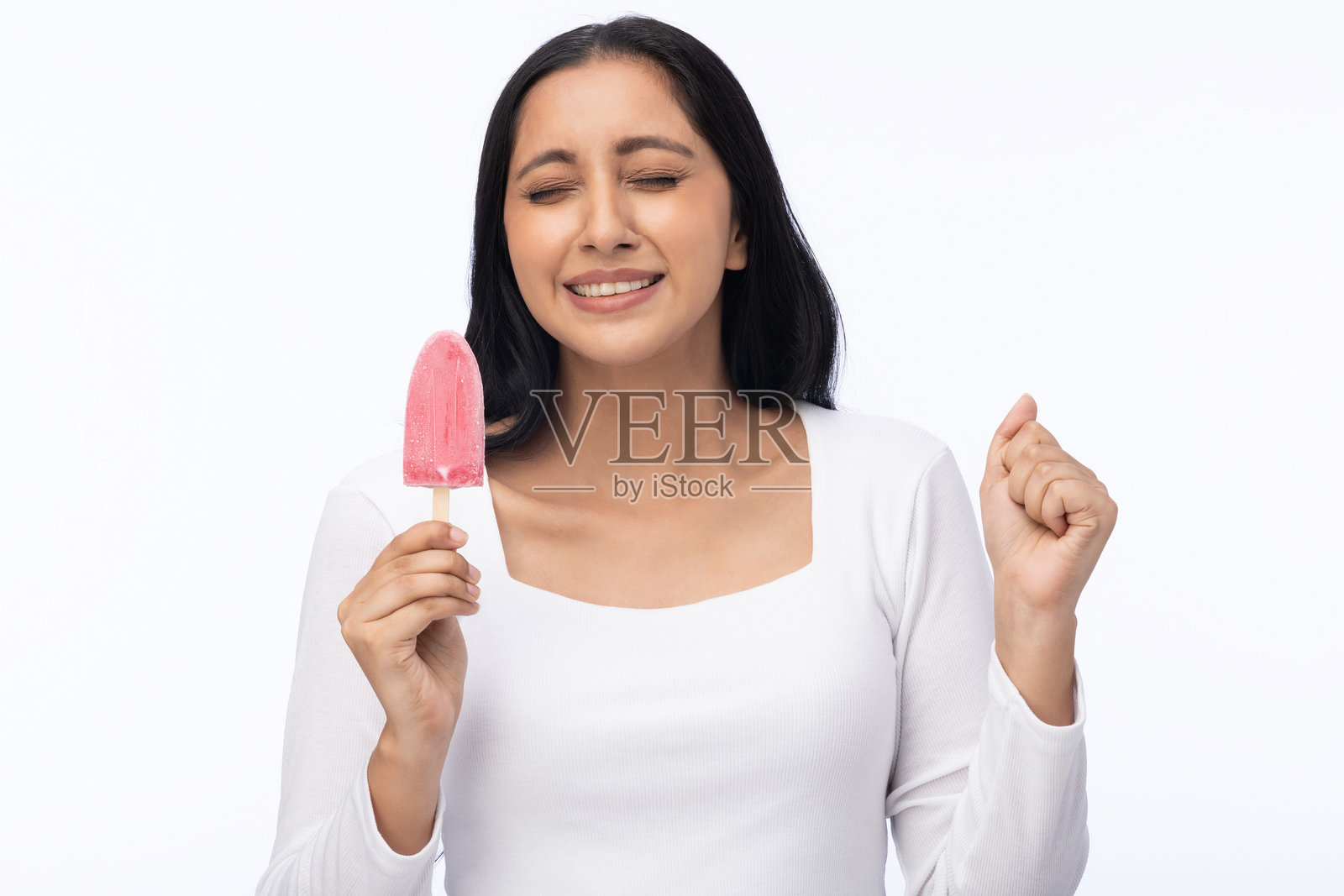 年轻女性穿着现代服装,享用草莓冰淇淋的肖像,背景为白色。照片摄影图片