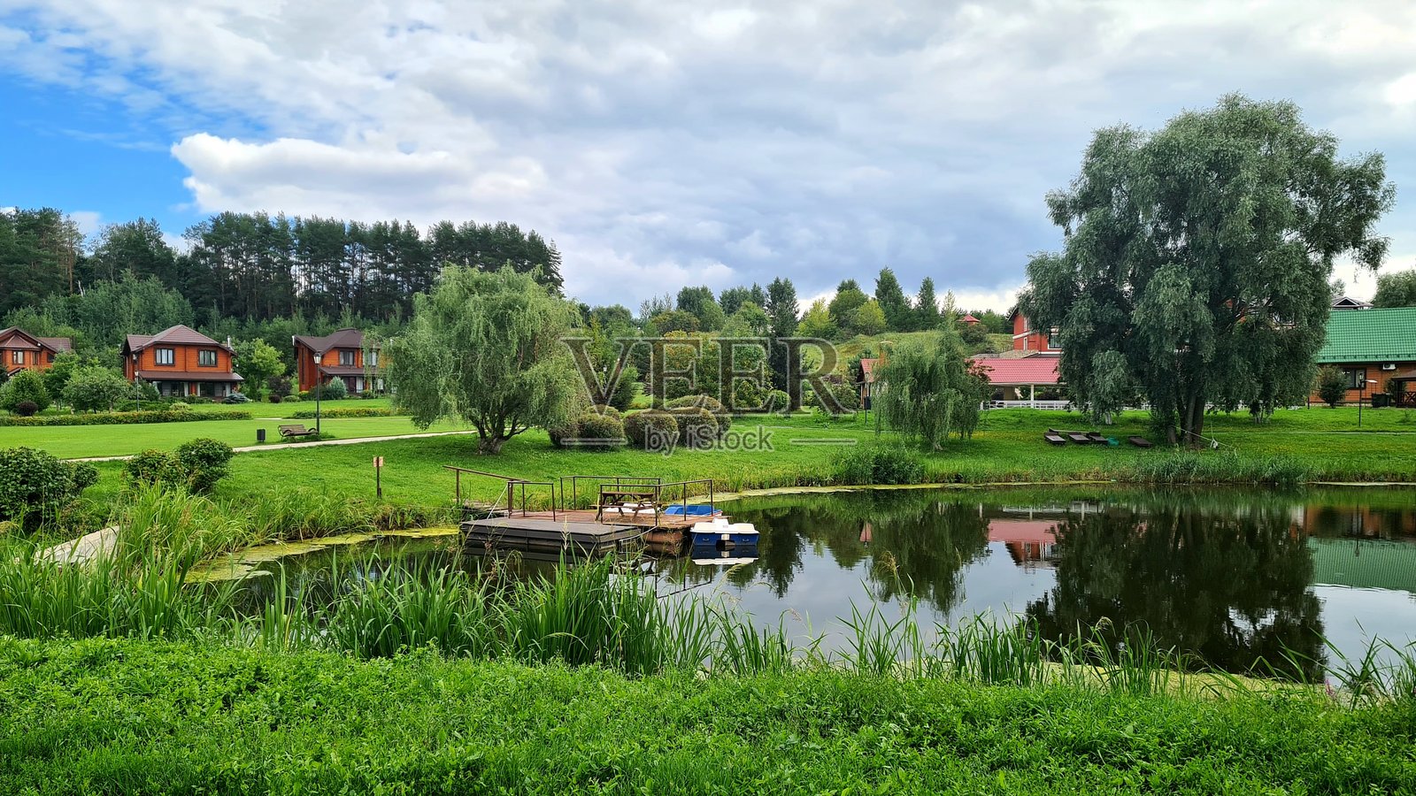 小池塘旁边有小屋和树林照片摄影图片