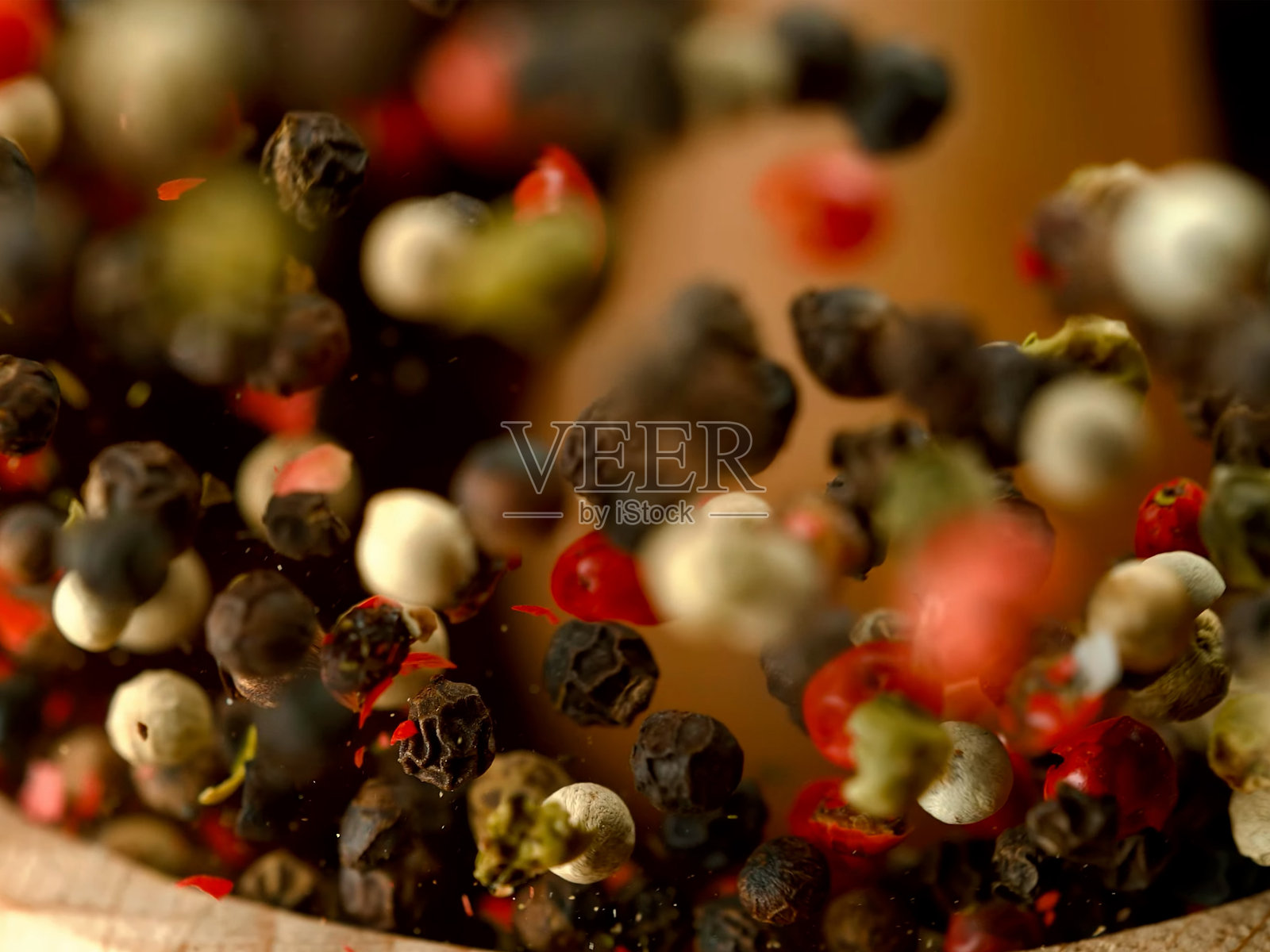 用研钵和杵手工研磨香料,红黑白胡椒,香料飞溅,特写微距镜头照片摄影图片