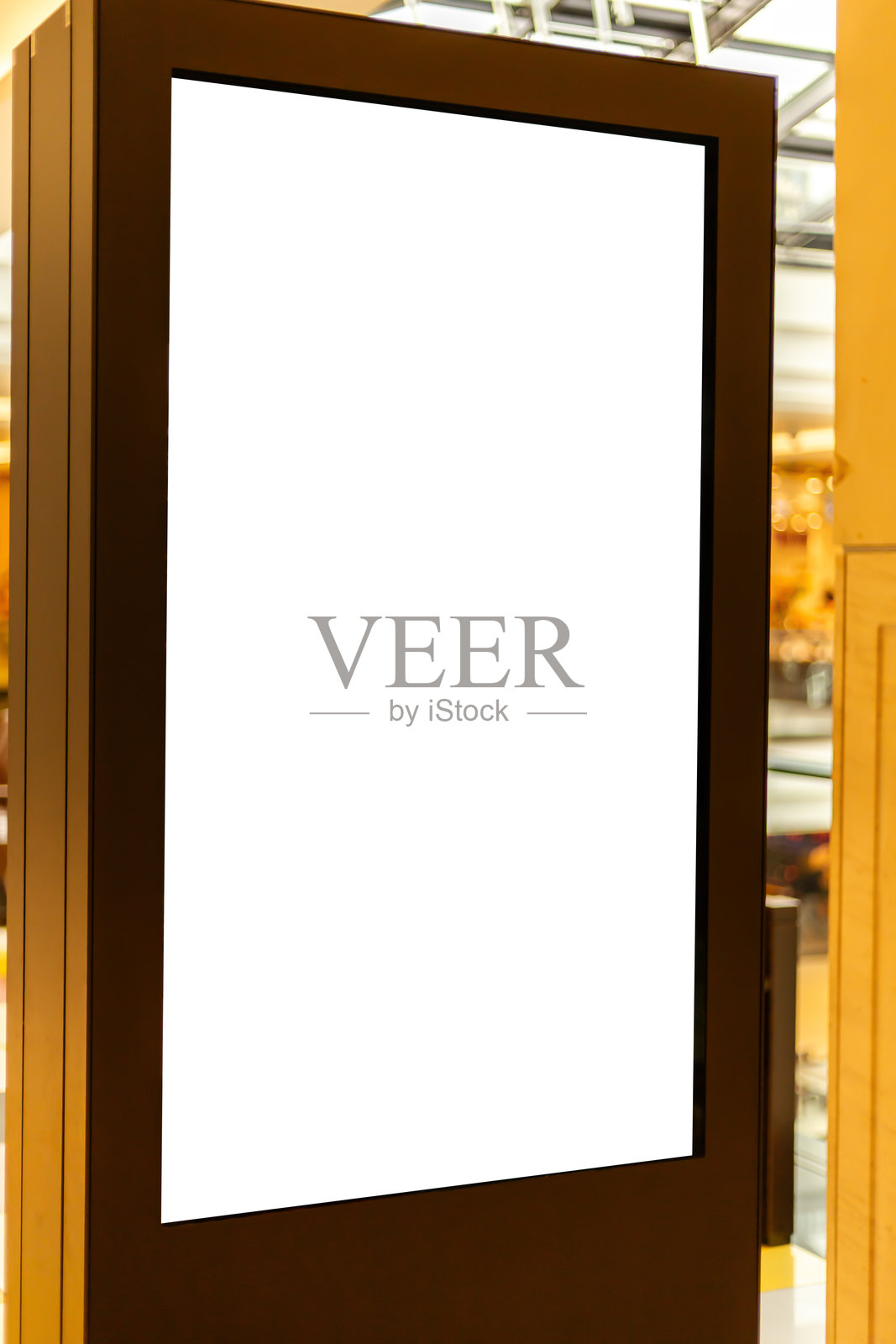 一个空白的数字展示架位于现代室内。空间充满温暖的灯光,营造出一种宜人的氛围。照片摄影图片