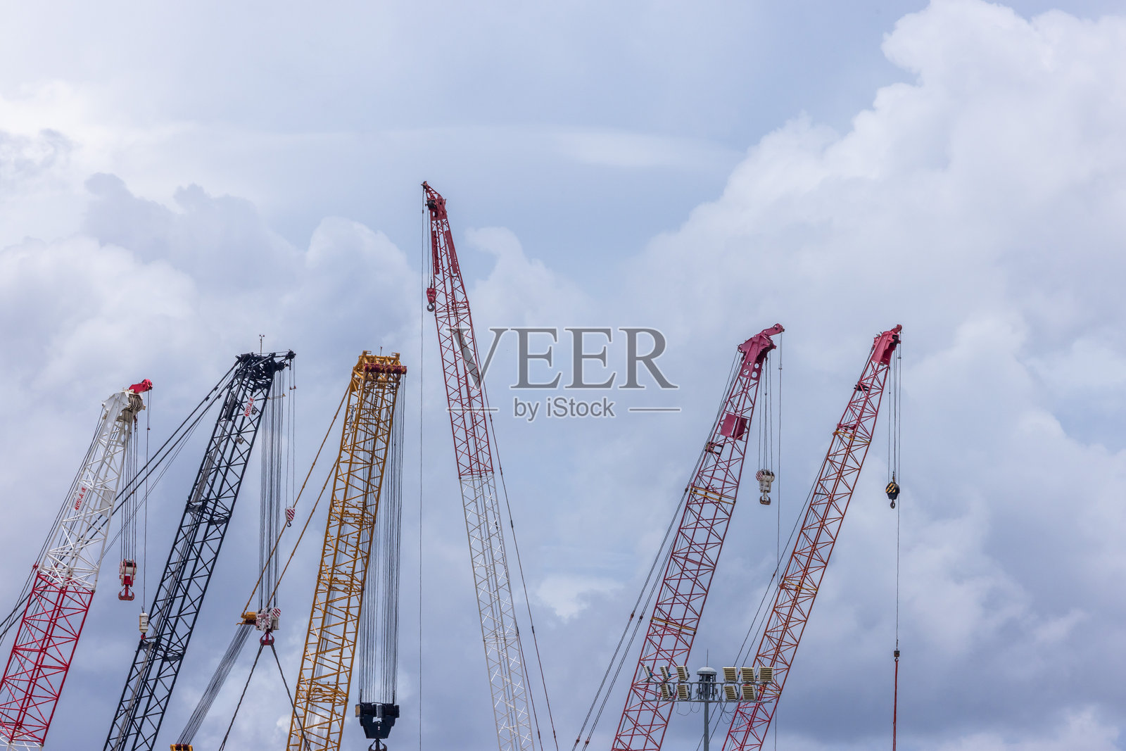 蓝天白云背景下的履带起重机,房地产行业。红色履带起重机在施工现场使用卷扬设备。起重机出租。建筑业务的起重机经销商。照片摄影图片