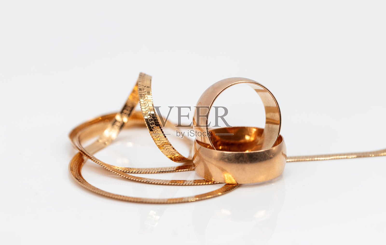 金色婚戒与编织手链照片摄影图片