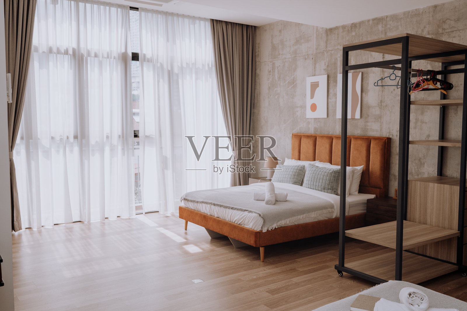 现代卧室配有豪华双人床、高品质床单和全景城市景观照片摄影图片