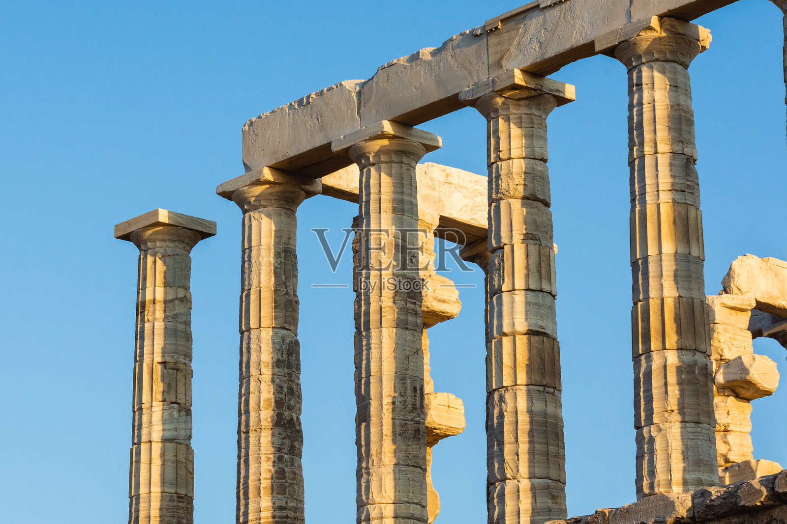 希腊苏尼翁角波塞冬神庙的阳光照耀下的多立克柱。照片摄影图片