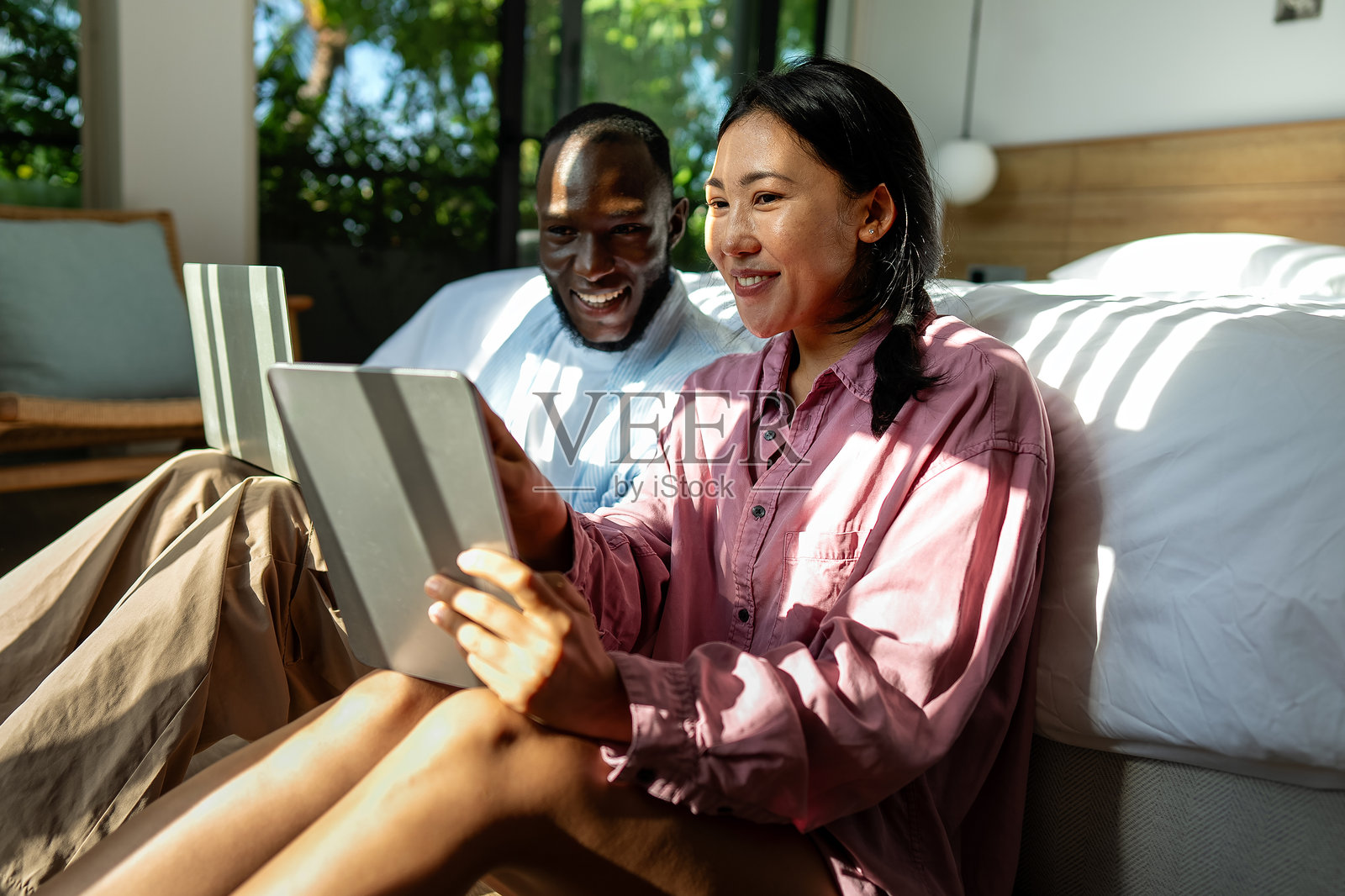 快乐的多元文化夫妇,正在使用笔记本电脑进行在线购物或支付。照片摄影图片