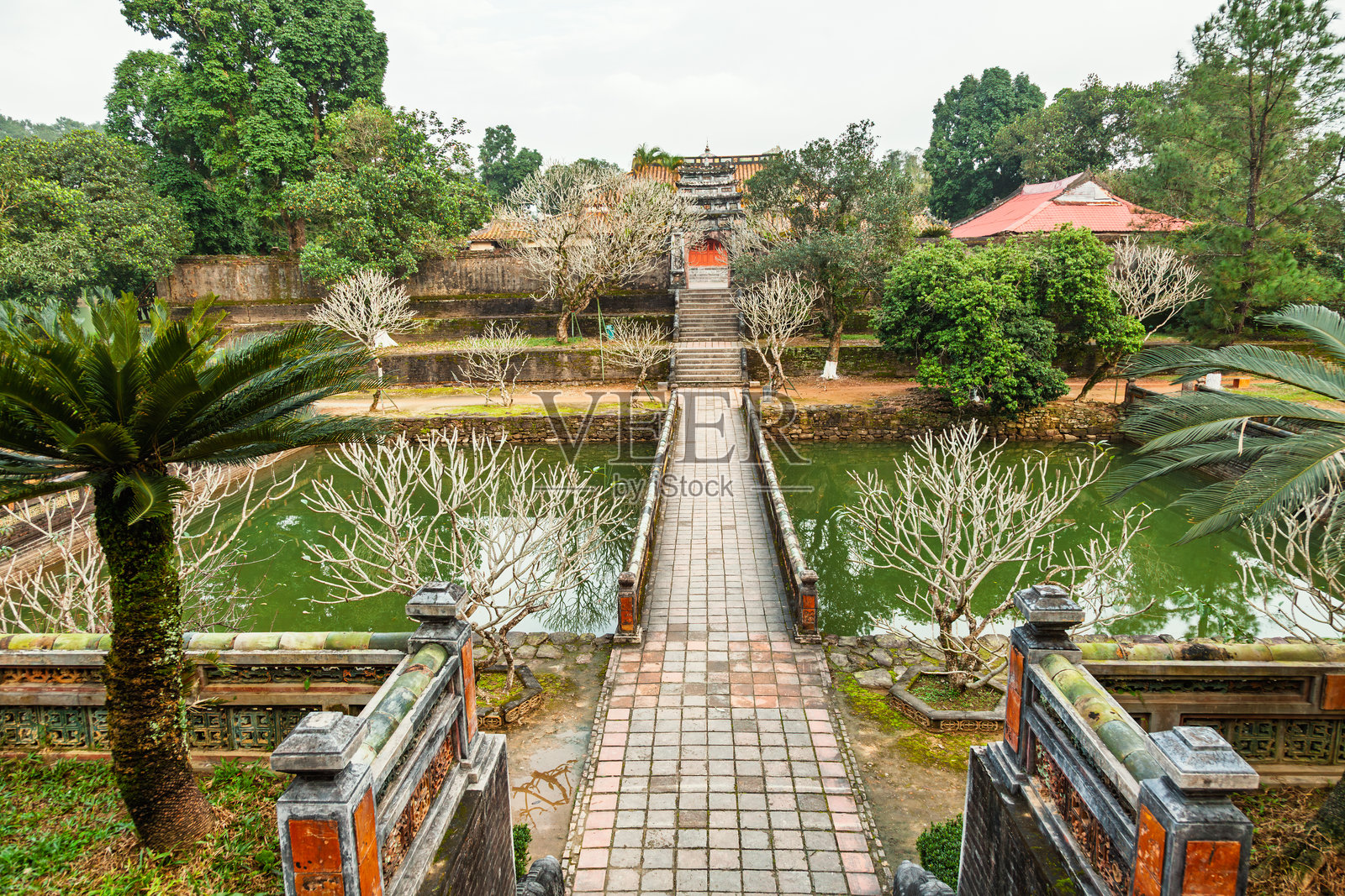 从高处俯瞰越南顺化明命皇陵的石桥,桥上通往历史悠久的神社,桥下是一个池塘。照片摄影图片