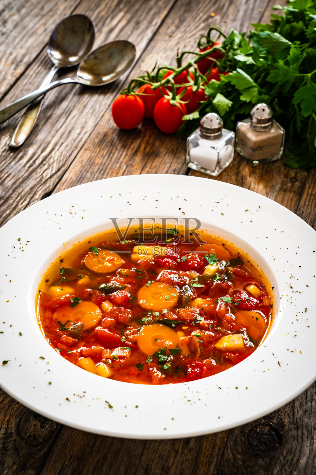 新鲜蔬菜汤配鹰嘴豆,盛在木桌上的白色碗里照片摄影图片