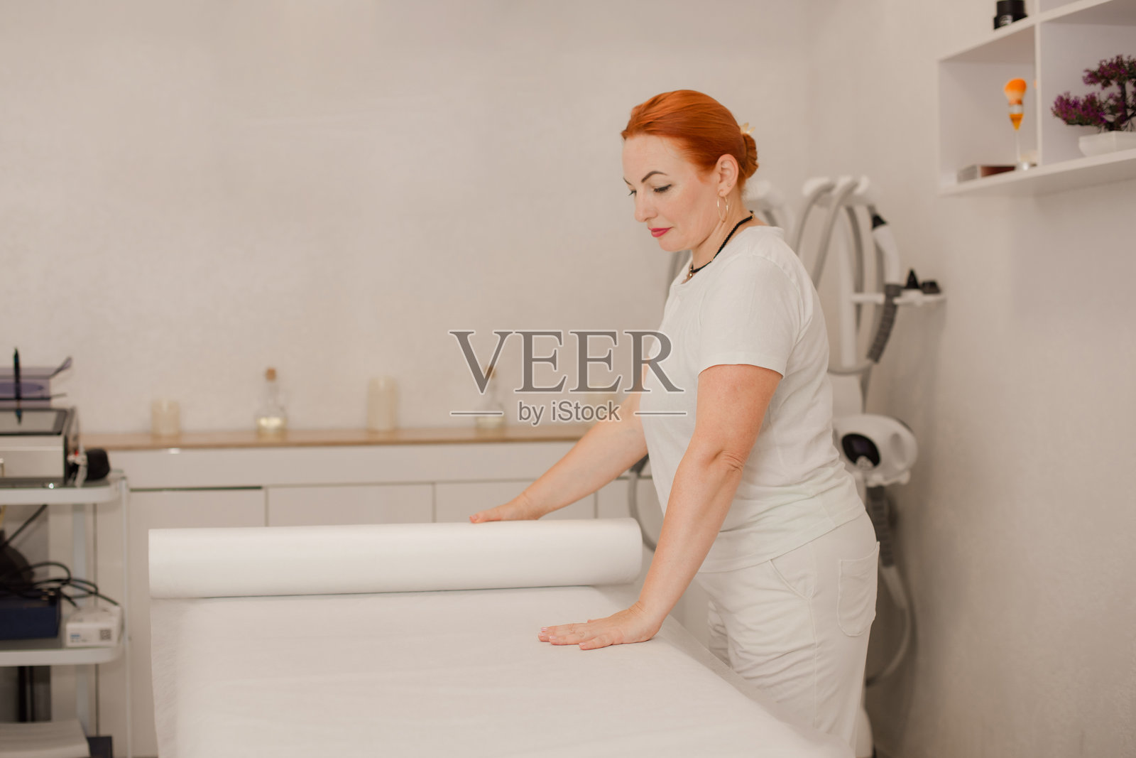 女按摩师在水疗沙龙为客户准备按摩床照片摄影图片