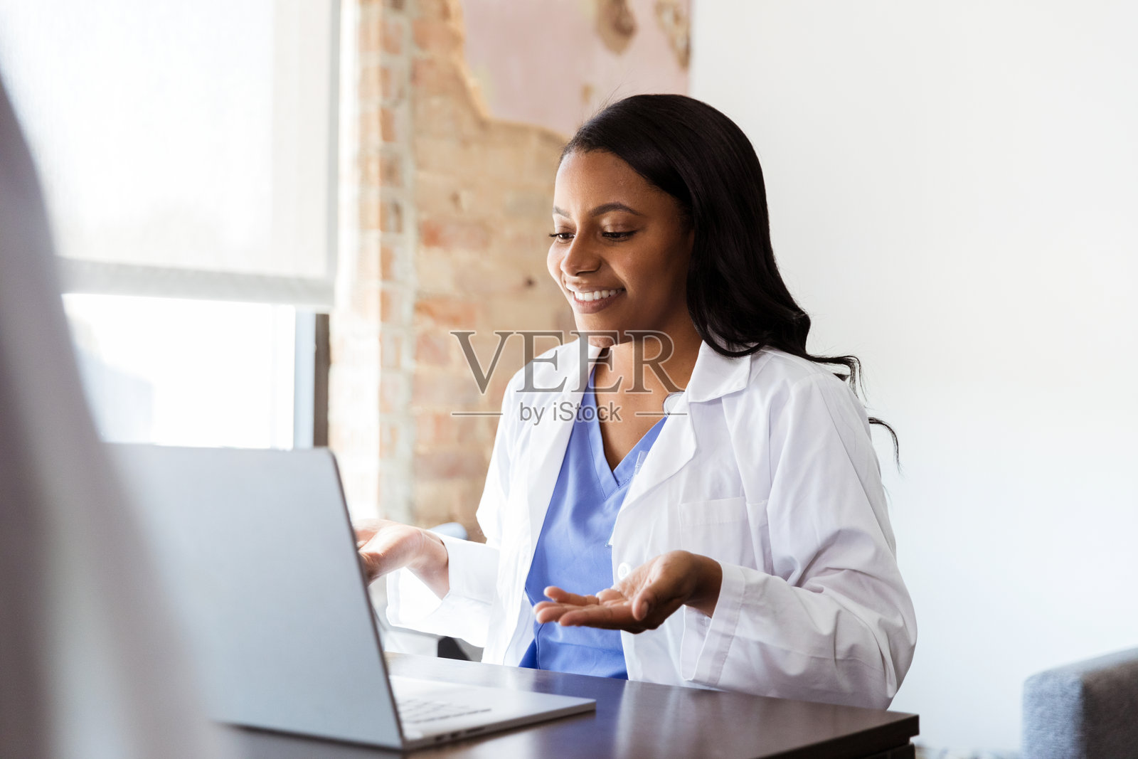 微笑的女医生使用笔记本电脑进行远程医疗照片摄影图片