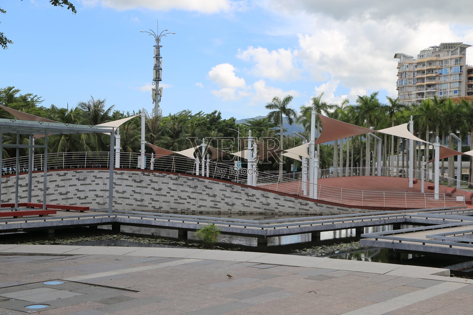 城市中的现代公共公园,设有舞台、座位区和水景。照片摄影图片