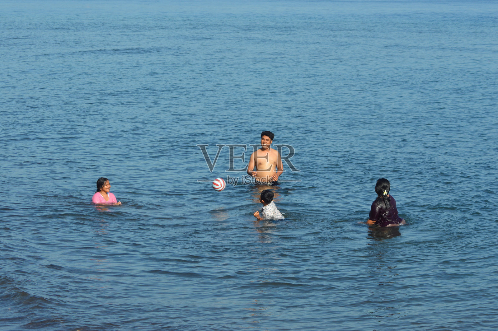 在热闹的海边家庭游戏中飞翔的球照片摄影图片