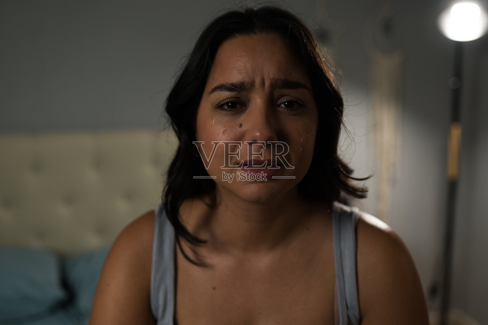 一位年轻拉丁女性在卧室里因分手而哭泣的肖像照片摄影图片
