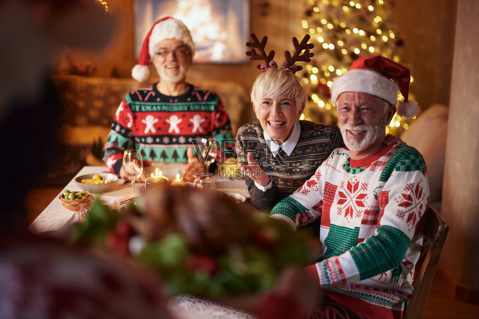 快乐的老年朋友们在餐桌上期待着新年的午餐。照片摄影图片