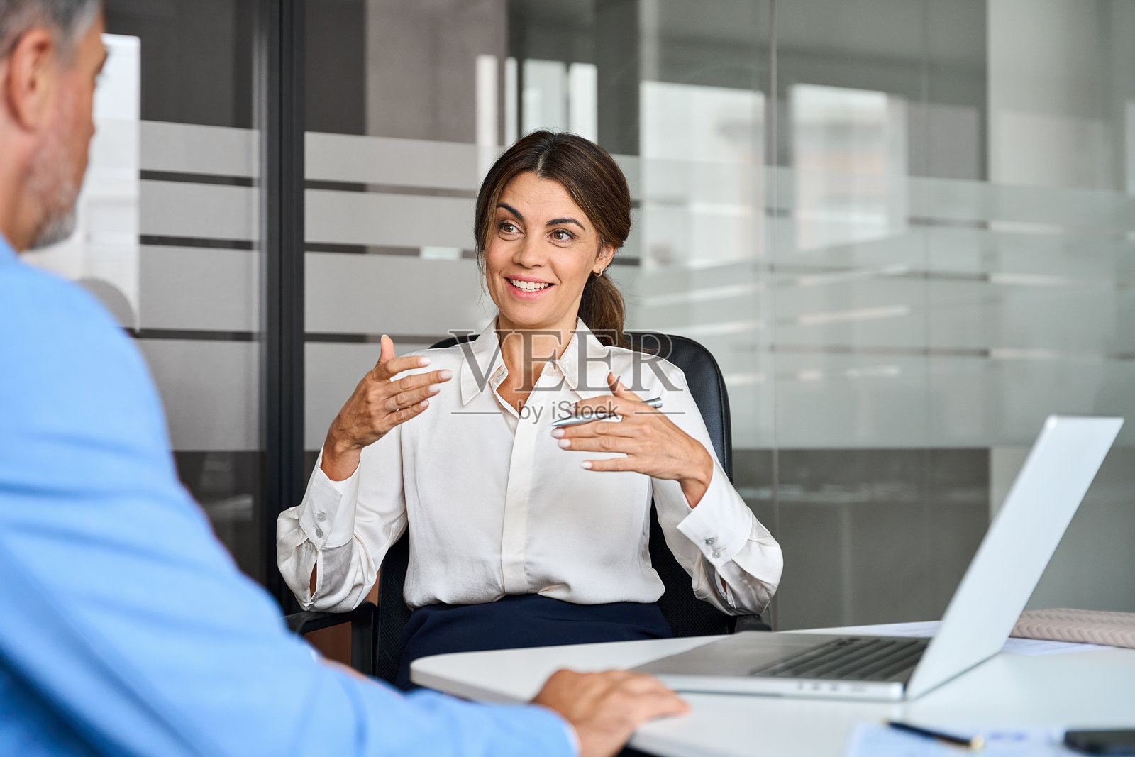 快乐的女性专业银行经理在办公室会议中咨询客户。照片摄影图片