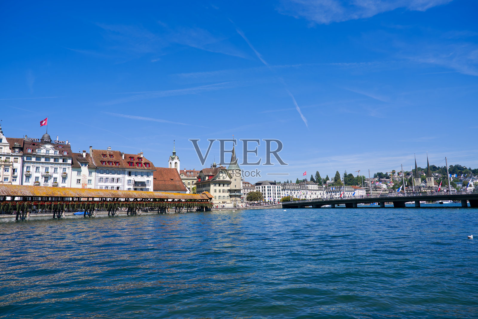 瑞士卢塞恩老城的著名教堂桥与瑞乌斯河以及名为Seebrücke的桥在阳光明媚的夏日下的城市风景。照片摄影图片