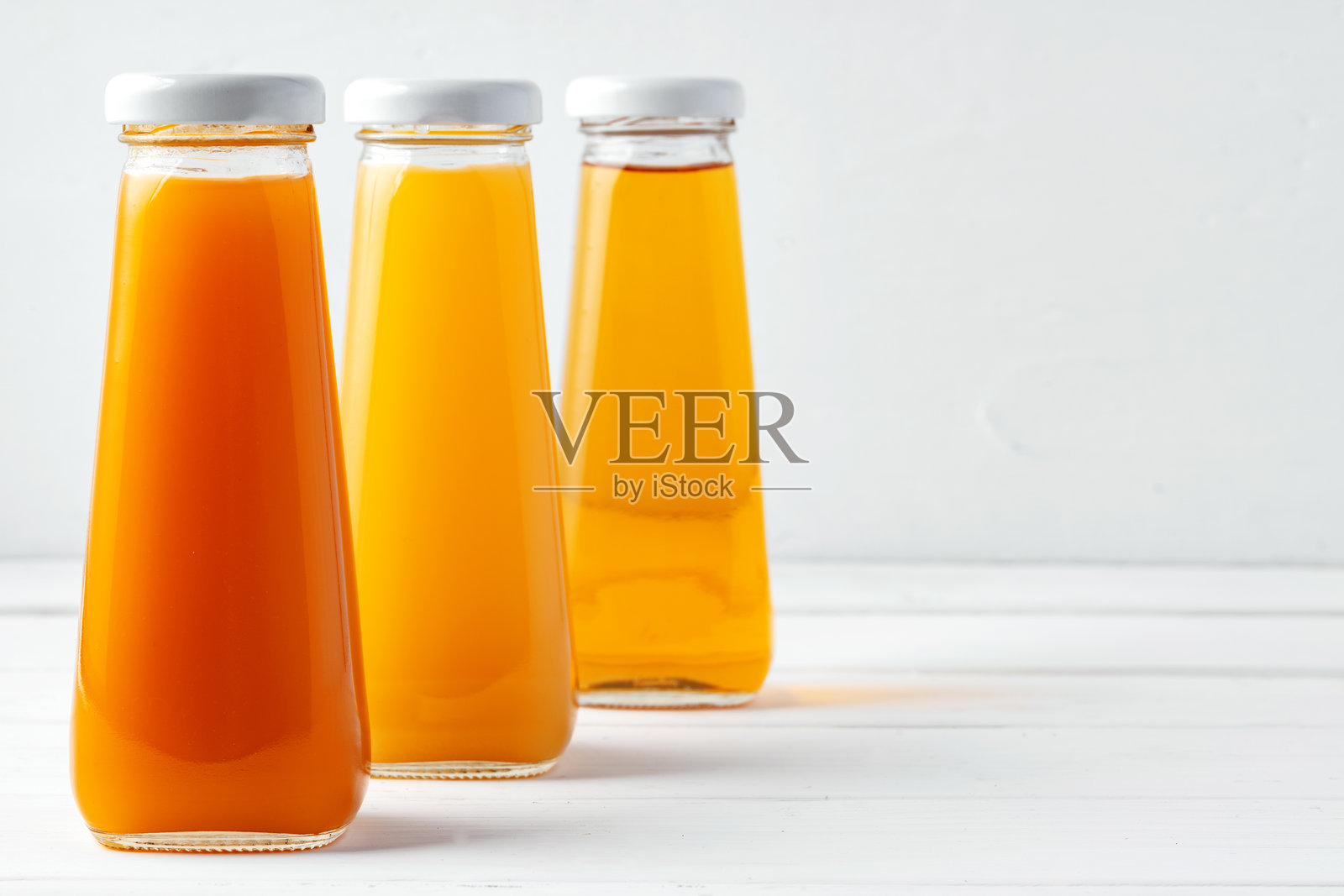 不同果汁的玻璃瓶在白色背景上照片摄影图片