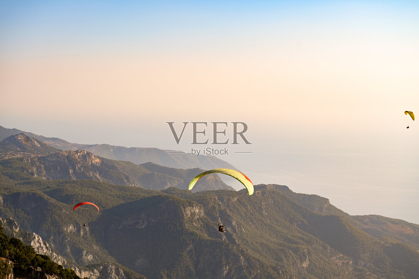 从巴巴达山跳伞的滑翔伞运动员在乌鲁登兹的背景下飞翔照片摄影图片