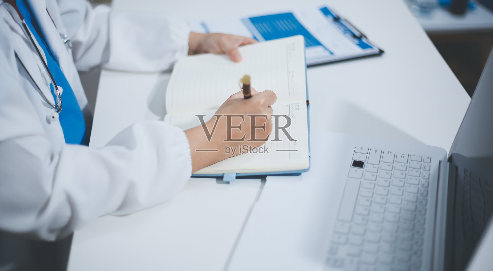 中年女性医生在诊室里使用笔记本电脑照片摄影图片