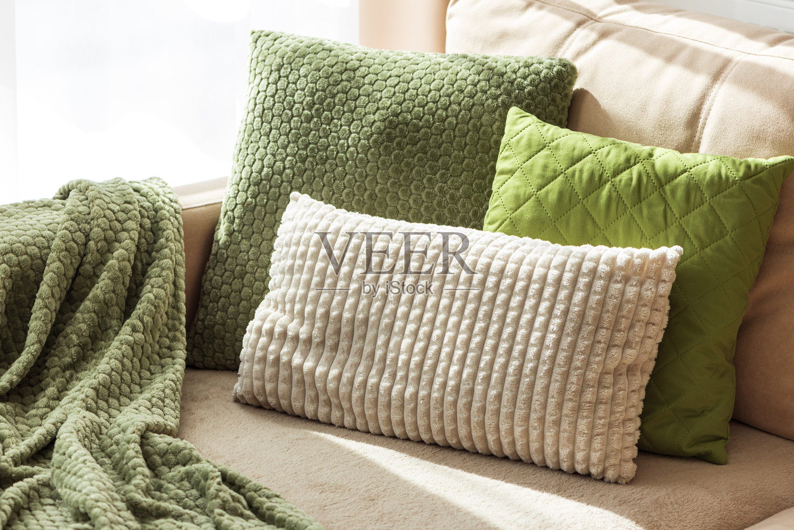 质感抱枕和毛毯放在舒适的米色沙发上照片摄影图片