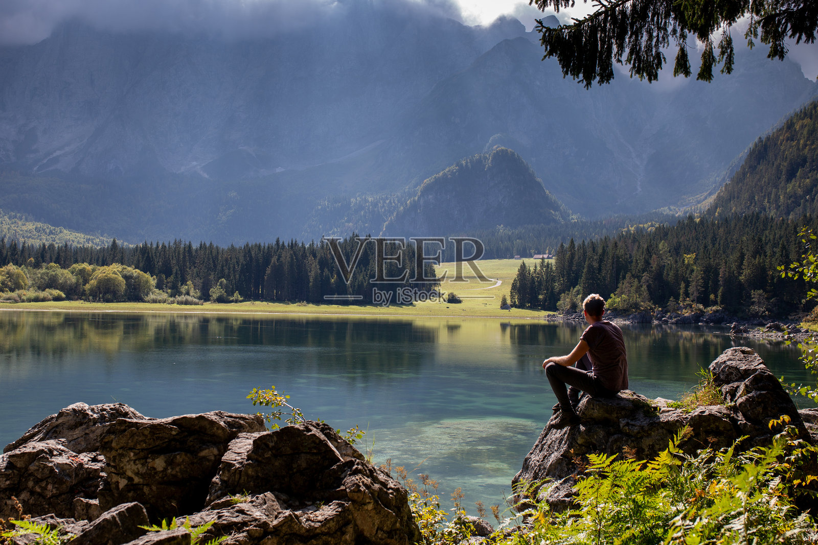 年轻男子在自然和山脉中沉思福西内湖照片摄影图片