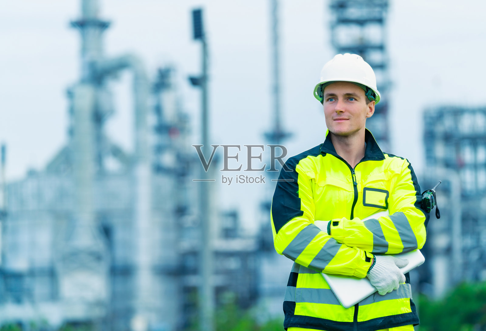 男性工程师在石油炼油厂施工现场工作。照片摄影图片