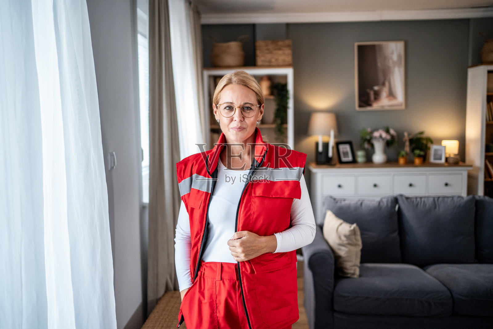 女救护员站在家中的客厅里照片摄影图片