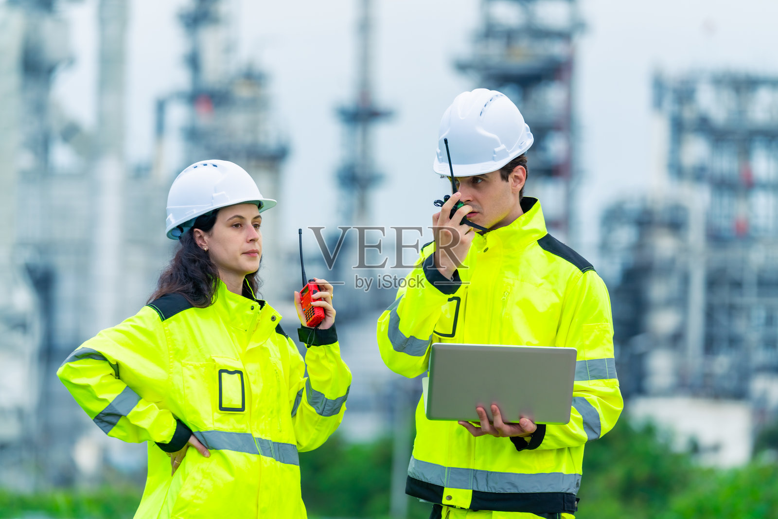 工程师团队在石油炼油厂建设工地上工作。照片摄影图片