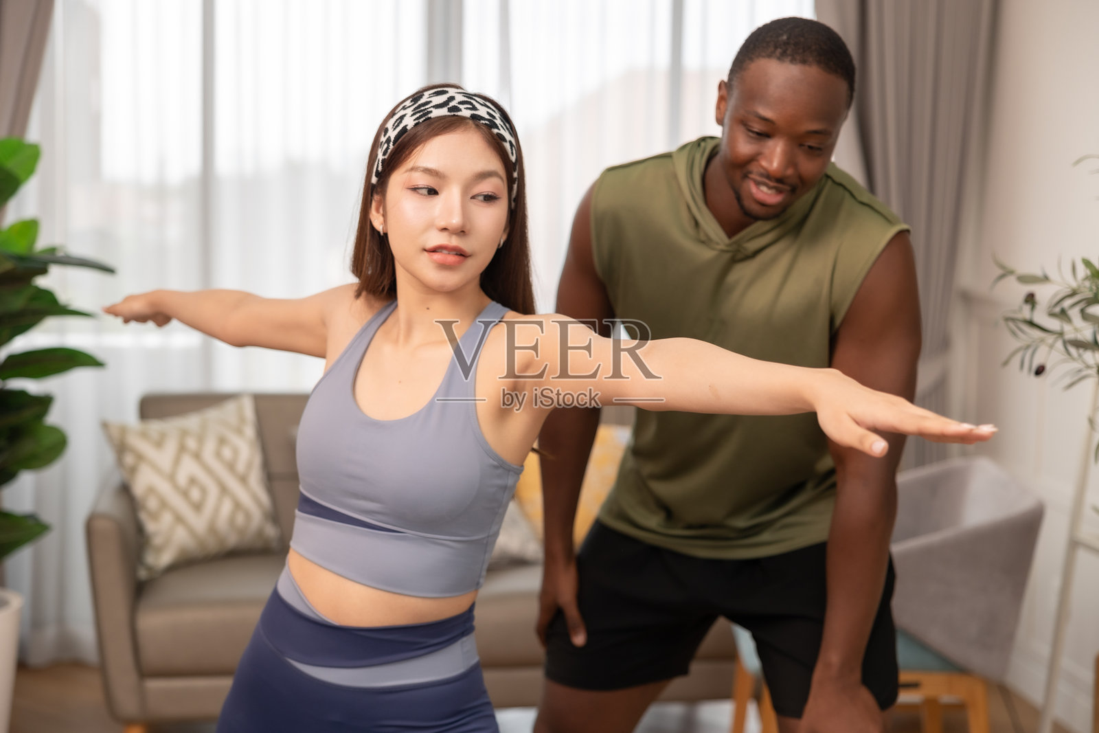 专业瑜伽教练在健身俱乐部或家中支持女性。照片摄影图片