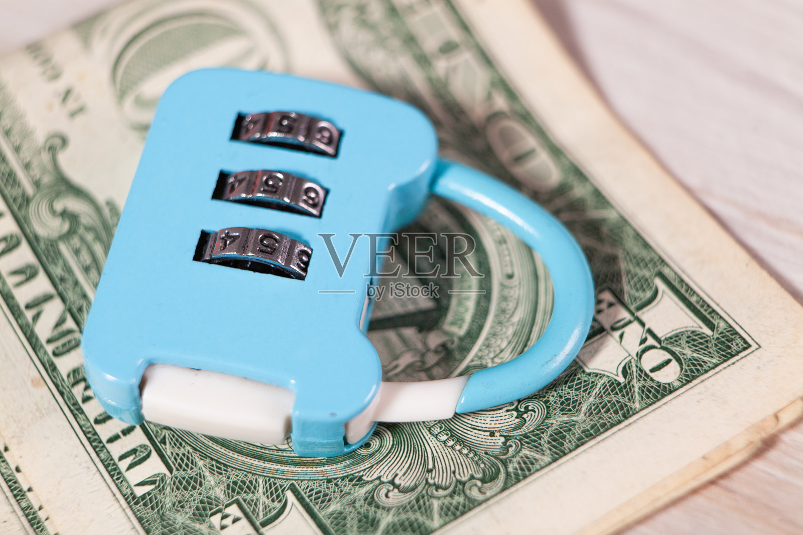 蓝色挂锁与美元钞票背景。金钱保护的概念。照片摄影图片