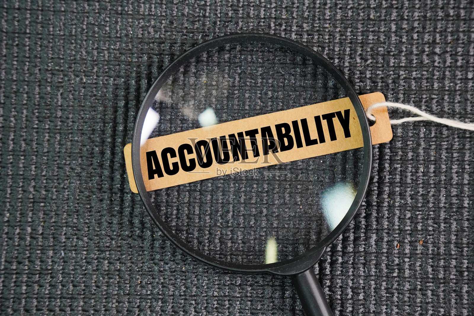 放大镜和一个写有“ACCOUNTABILITY”的纸标签。接受对自己行为、决策和表现的责任,并有义务解释这些责任。照片摄影图片