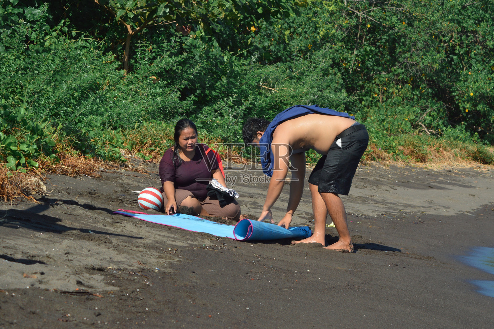 父母在沙滩上休息时整理物品照片摄影图片