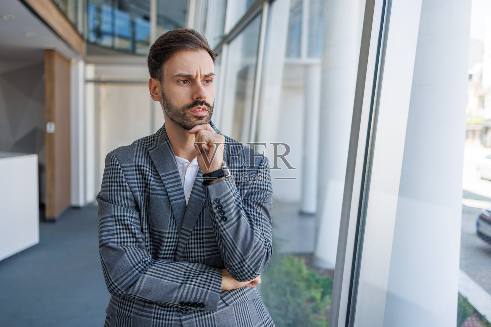 商人在办公室窗边思考,做出重要决定照片摄影图片