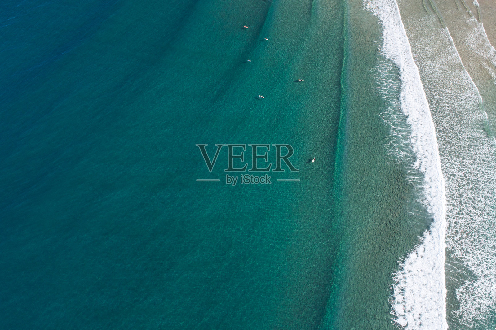 从上方拍摄的无人机镜头,展示人们在长板上冲浪,鸟瞰视角。照片摄影图片