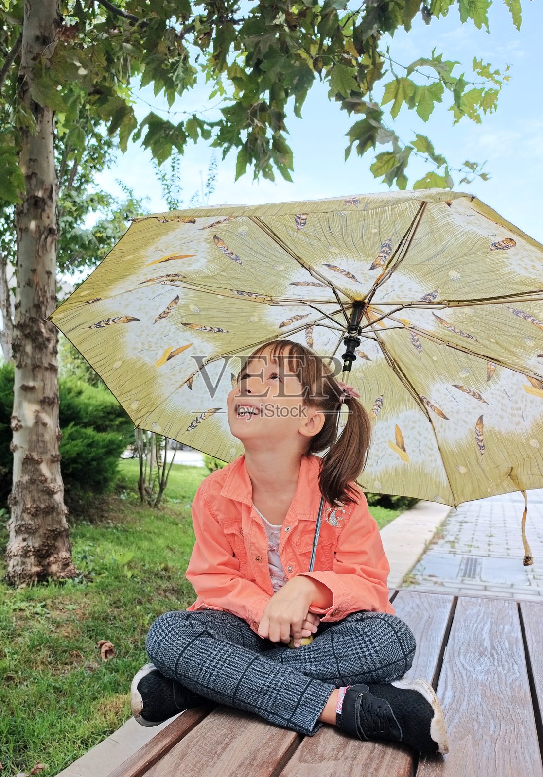 公园里拿着雨伞的小女孩照片摄影图片