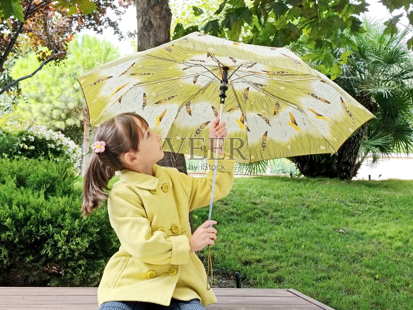 公园里拿着雨伞的小女孩照片摄影图片