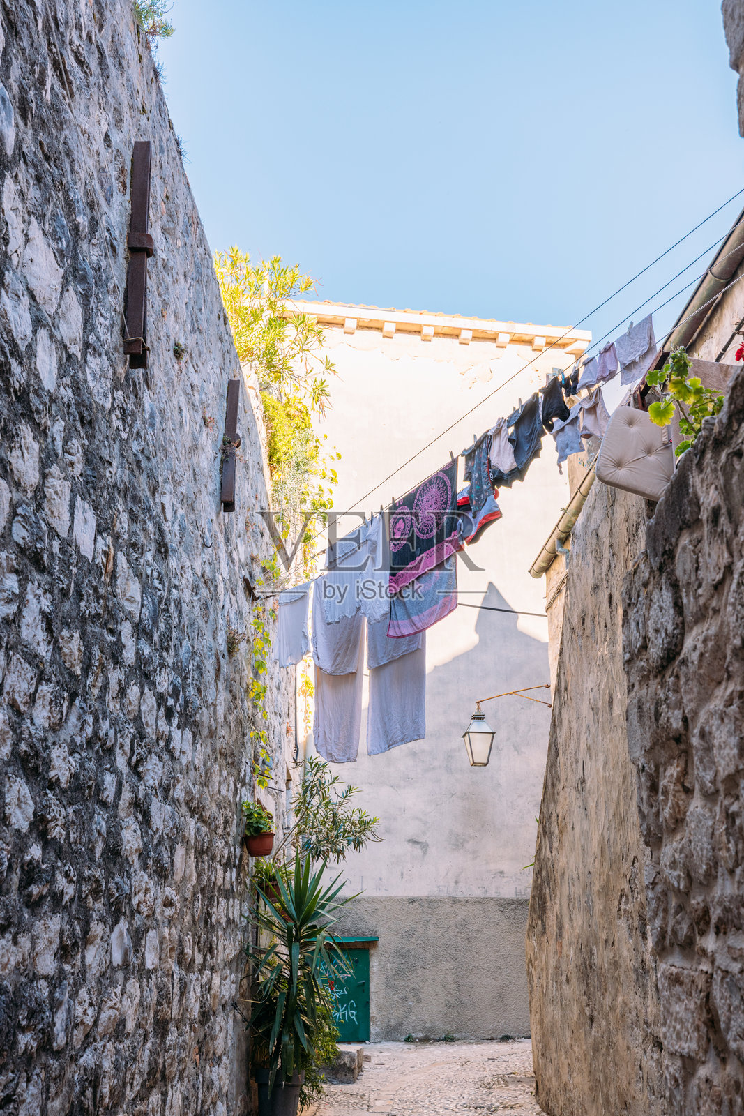 狭窄的石巷,外面晾晒着衣物照片摄影图片
