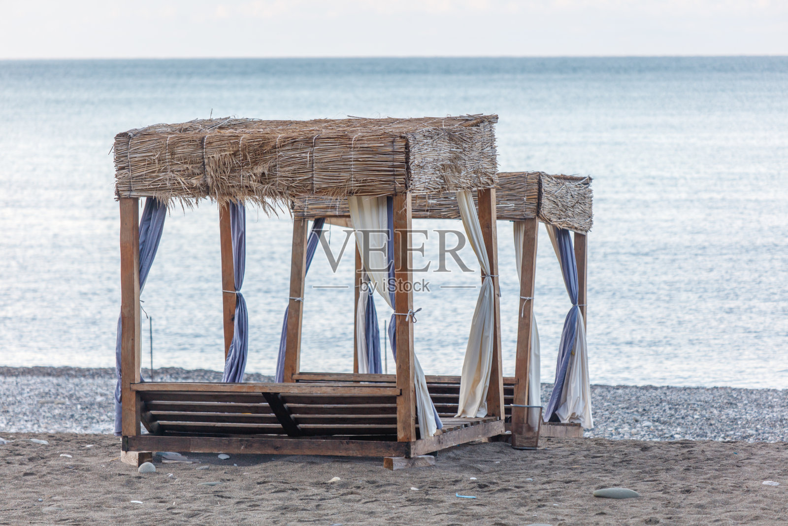 两个带有蓝白窗帘的海滩遮阳伞照片摄影图片