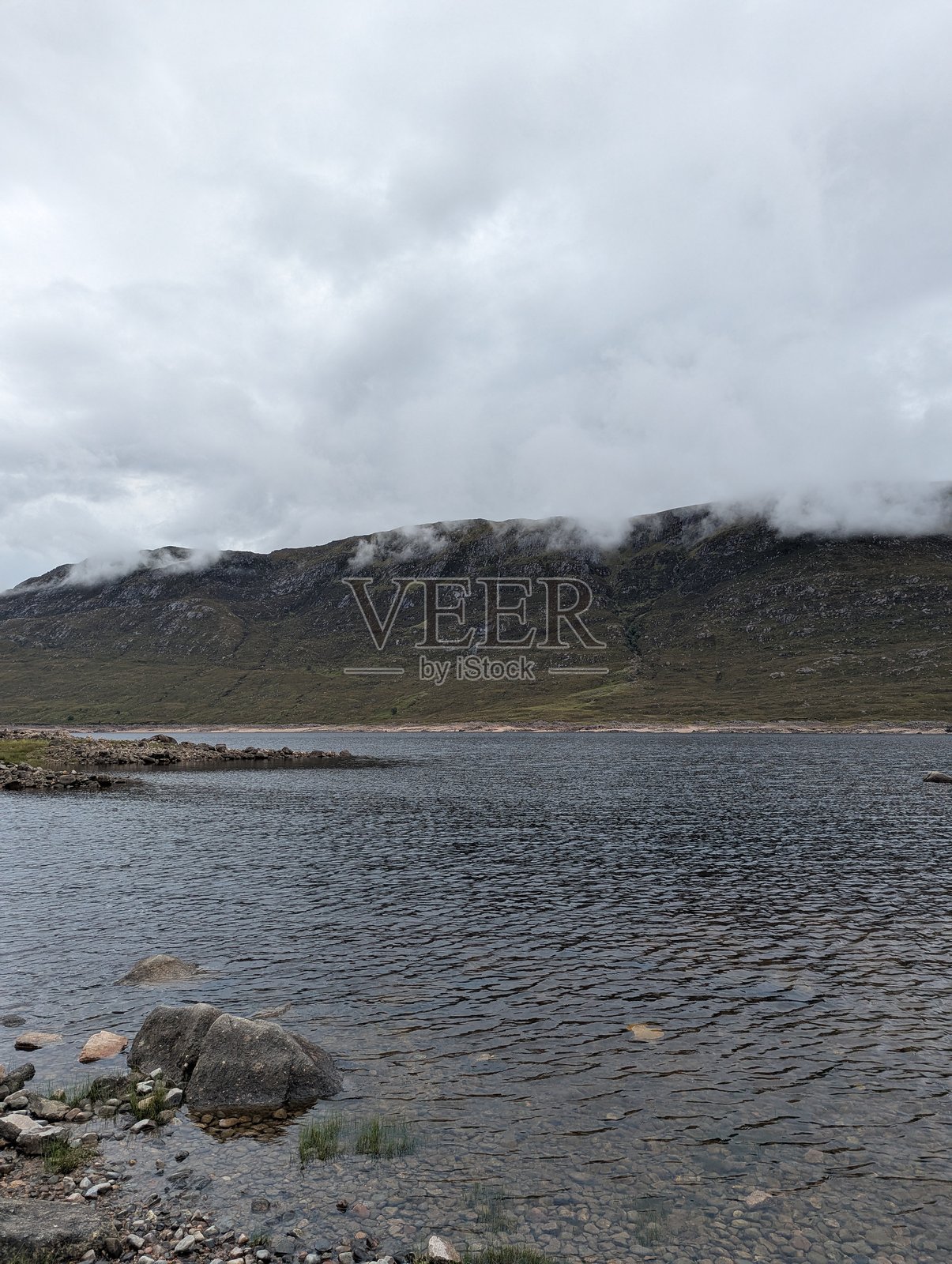 苏格兰斯凯岛上雾气缭绕的湖泊和被云层覆盖的山脉照片摄影图片