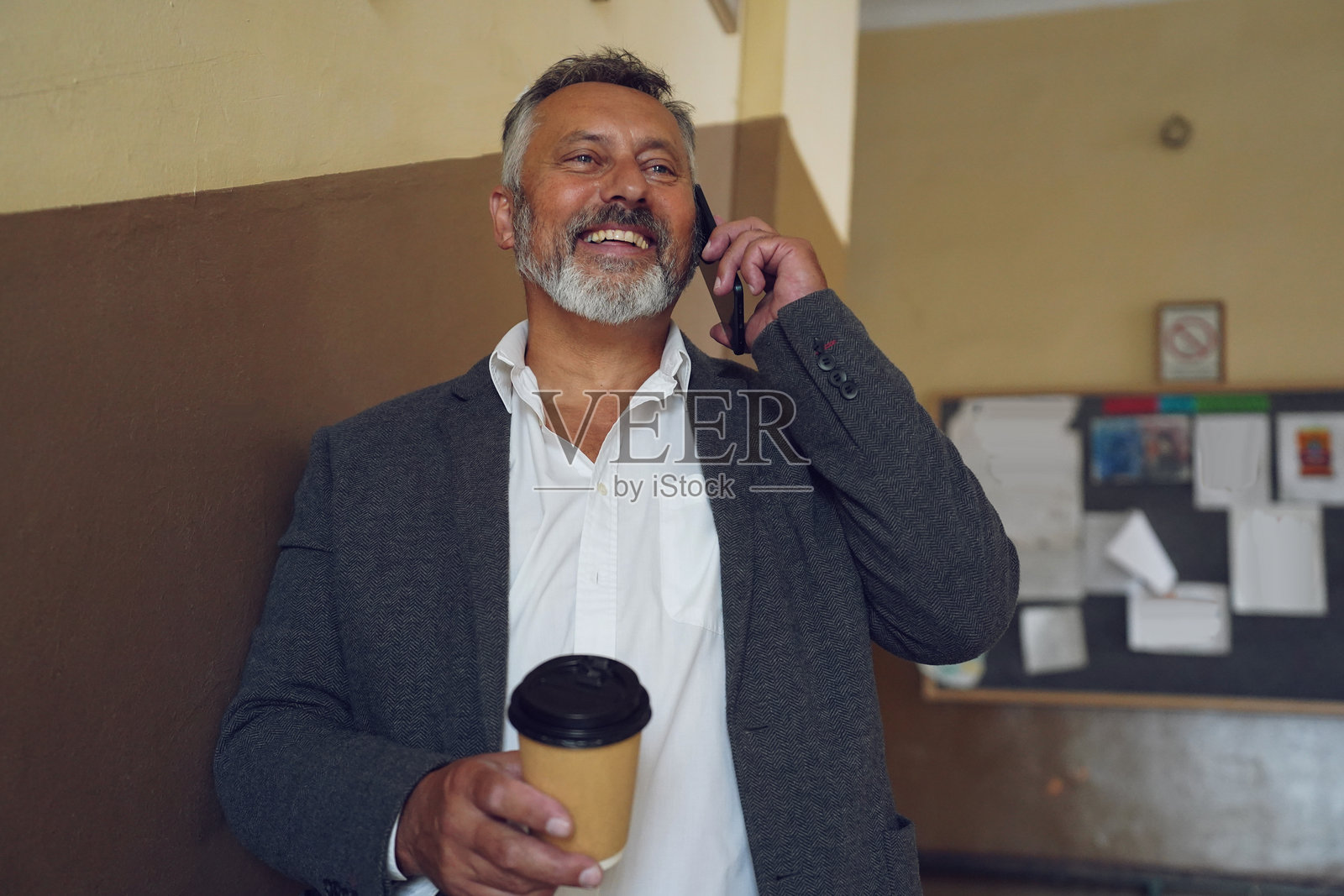 年长的老师在学校走廊享受咖啡休息时间照片摄影图片