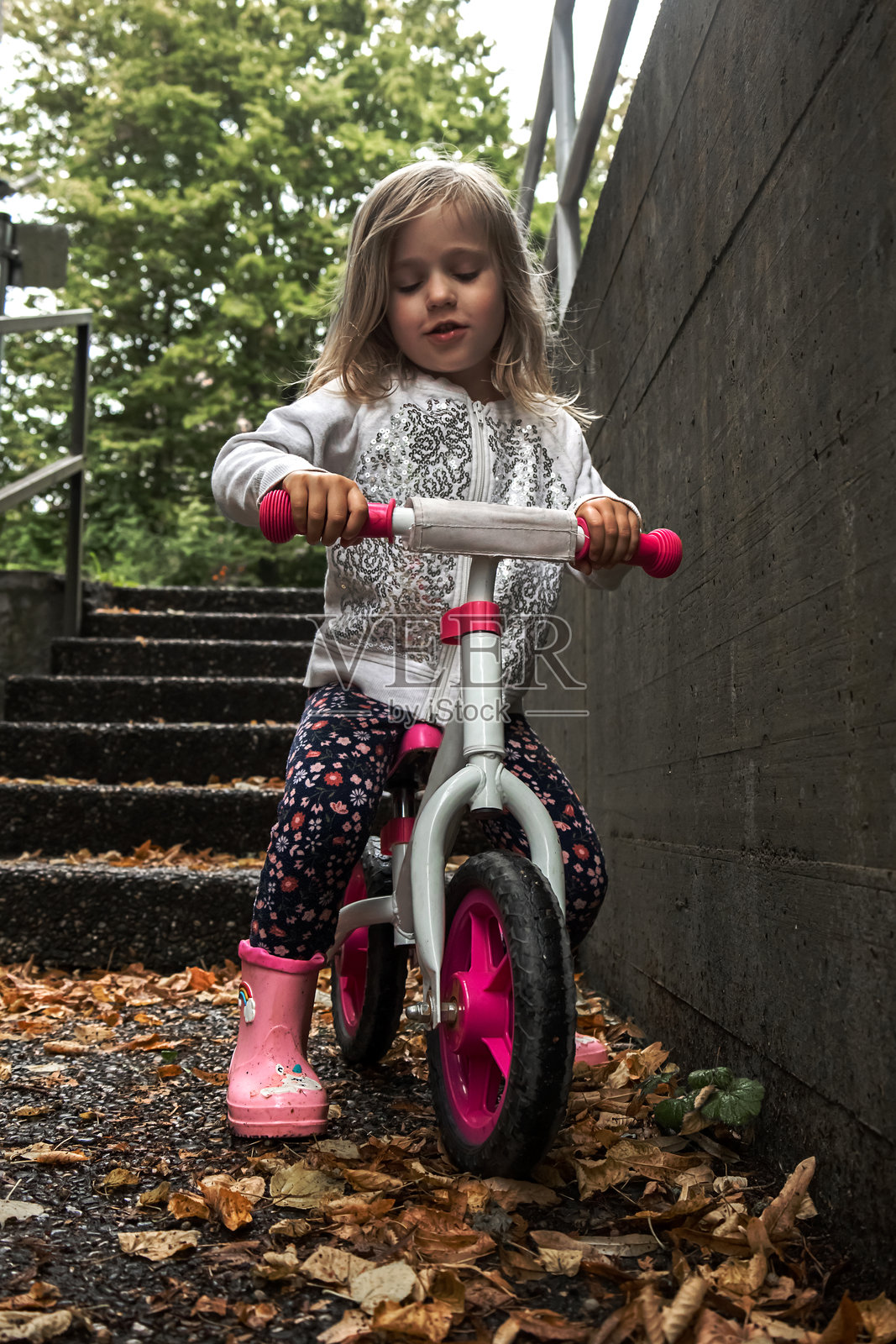 女孩在户外的潮湿秋季楼梯上玩平衡车照片摄影图片