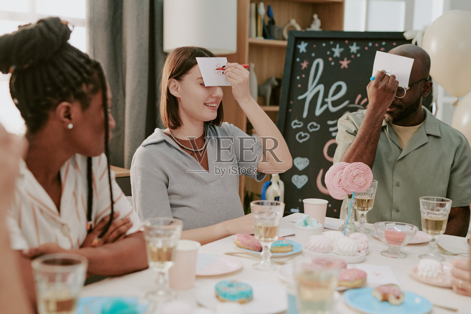 一群年轻的多民族朋友在宝宝派对上玩猜谜游戏照片摄影图片
