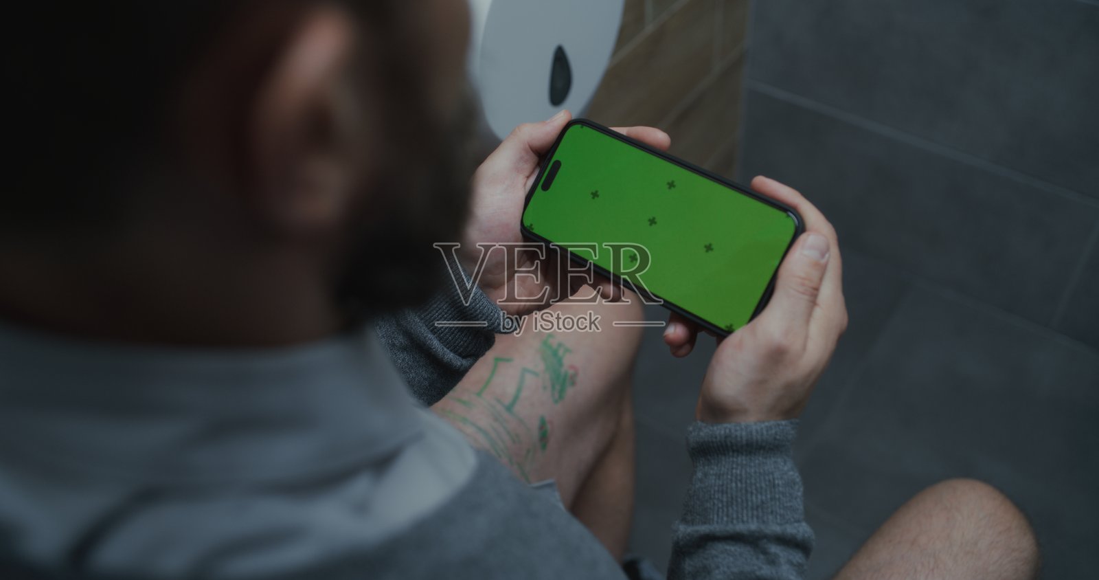 男性上班族坐在马桶上,使用手机,带有抠像背景照片摄影图片