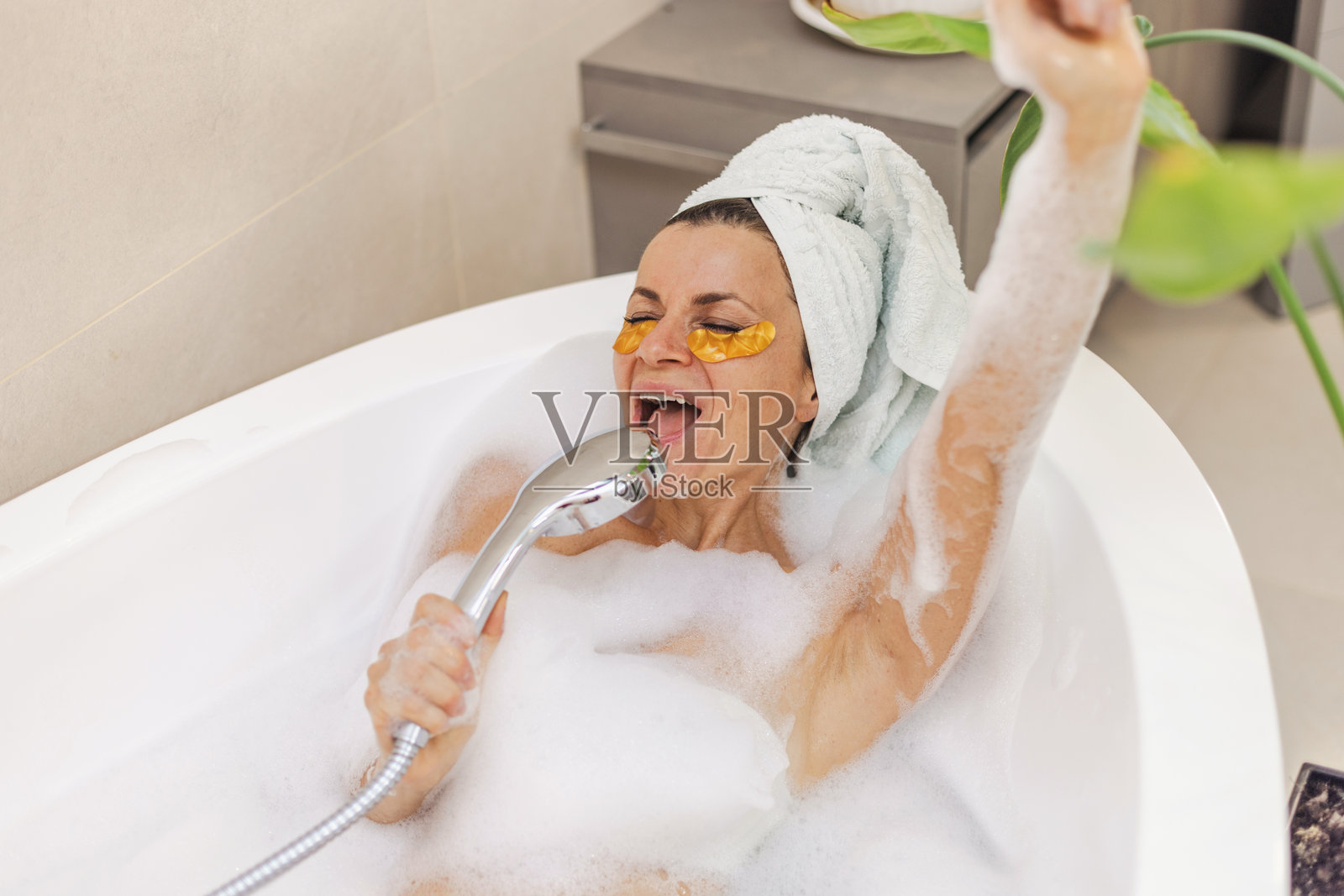 放松的沐浴时光,有淋浴、毛巾包头和植物氛围照片摄影图片