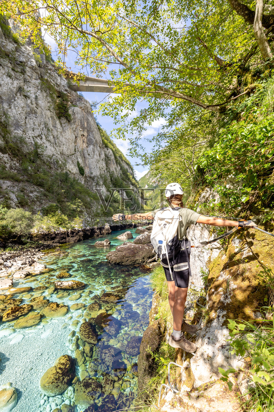 女子在清澈的河边岩石悬崖上保持平衡照片摄影图片