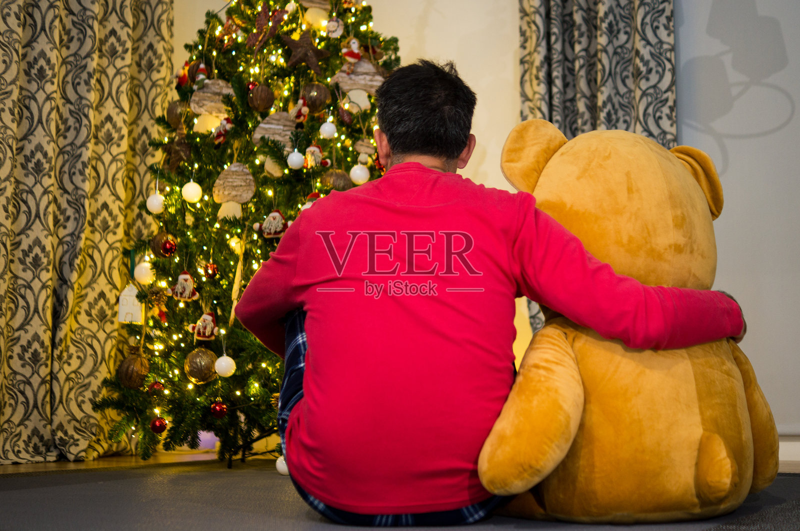 男人拥抱巨型泰迪熊照片摄影图片