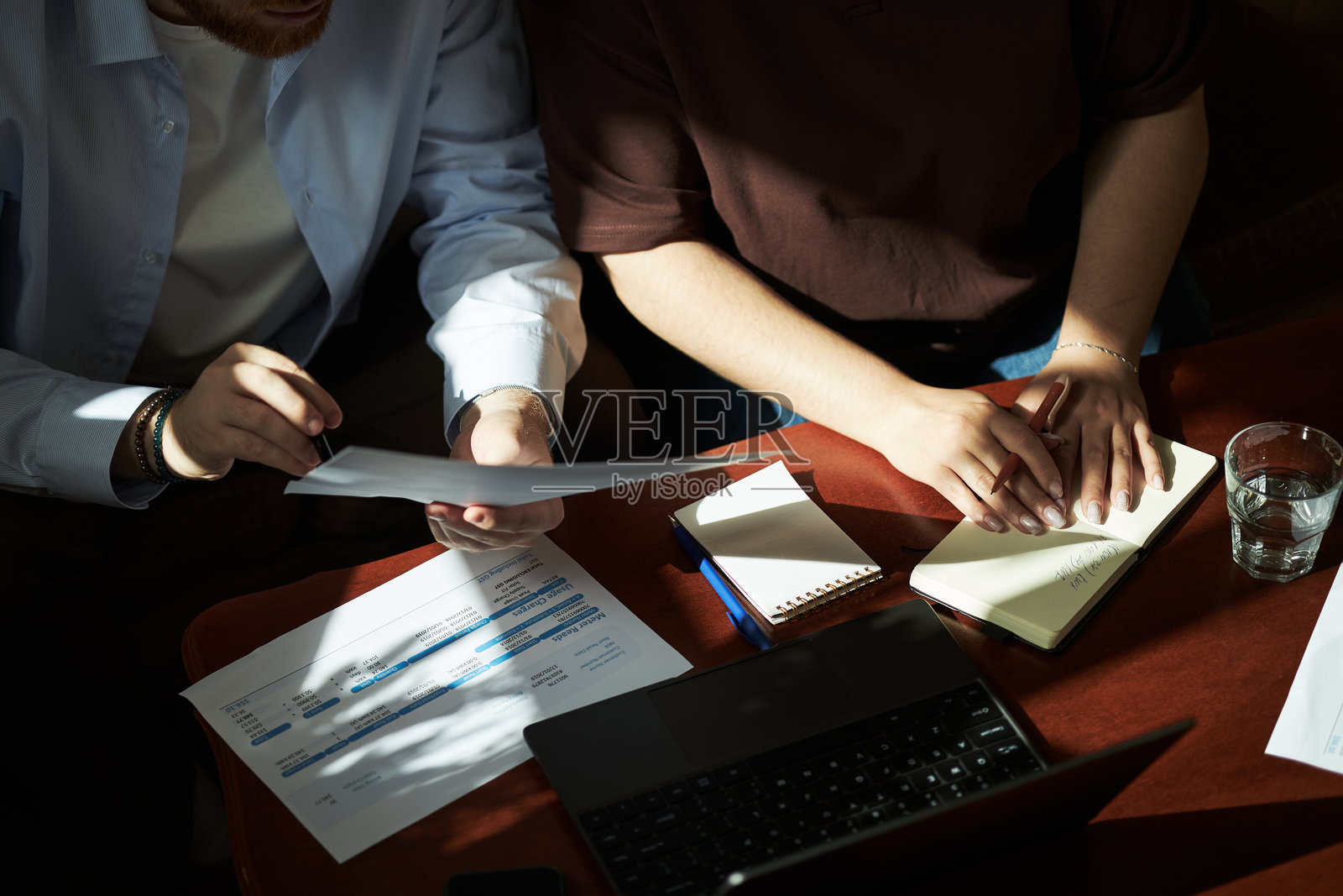 年轻的成年男女一起在桌边审阅财务文件照片摄影图片
