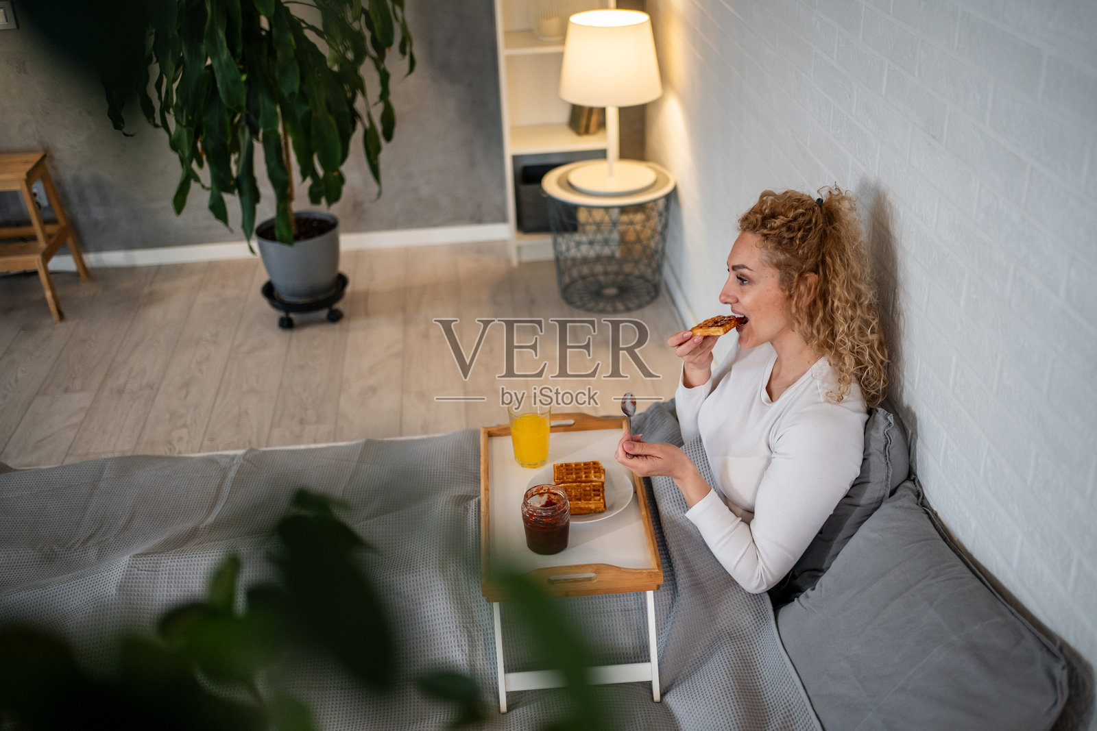 女人在家床上享用早餐华夫饼照片摄影图片